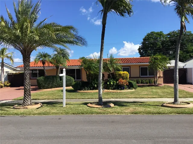 a view of a house with a yard and palm tree