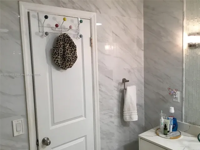 a view of a patio with table and chairs potted plants and floor to ceiling window