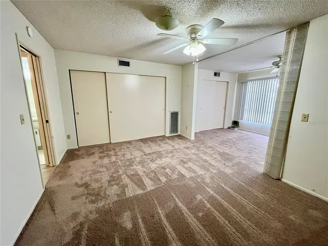 a view of a big room with closet and chandelier fan