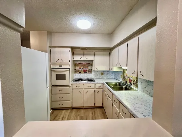 a kitchen with a stove sink and cabinets