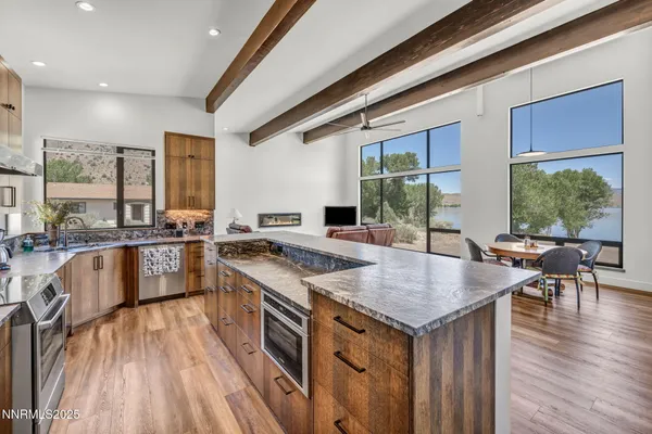 a kitchen with kitchen island a large counter top stainless steel appliances and cabinets