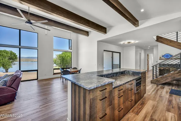 a kitchen with stainless steel appliances granite countertop a sink a stove and a wooden cabinets
