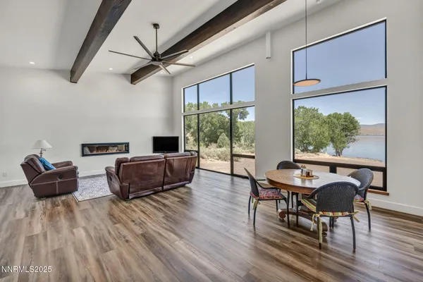 a living room with furniture a flat screen tv and a floor to ceiling window