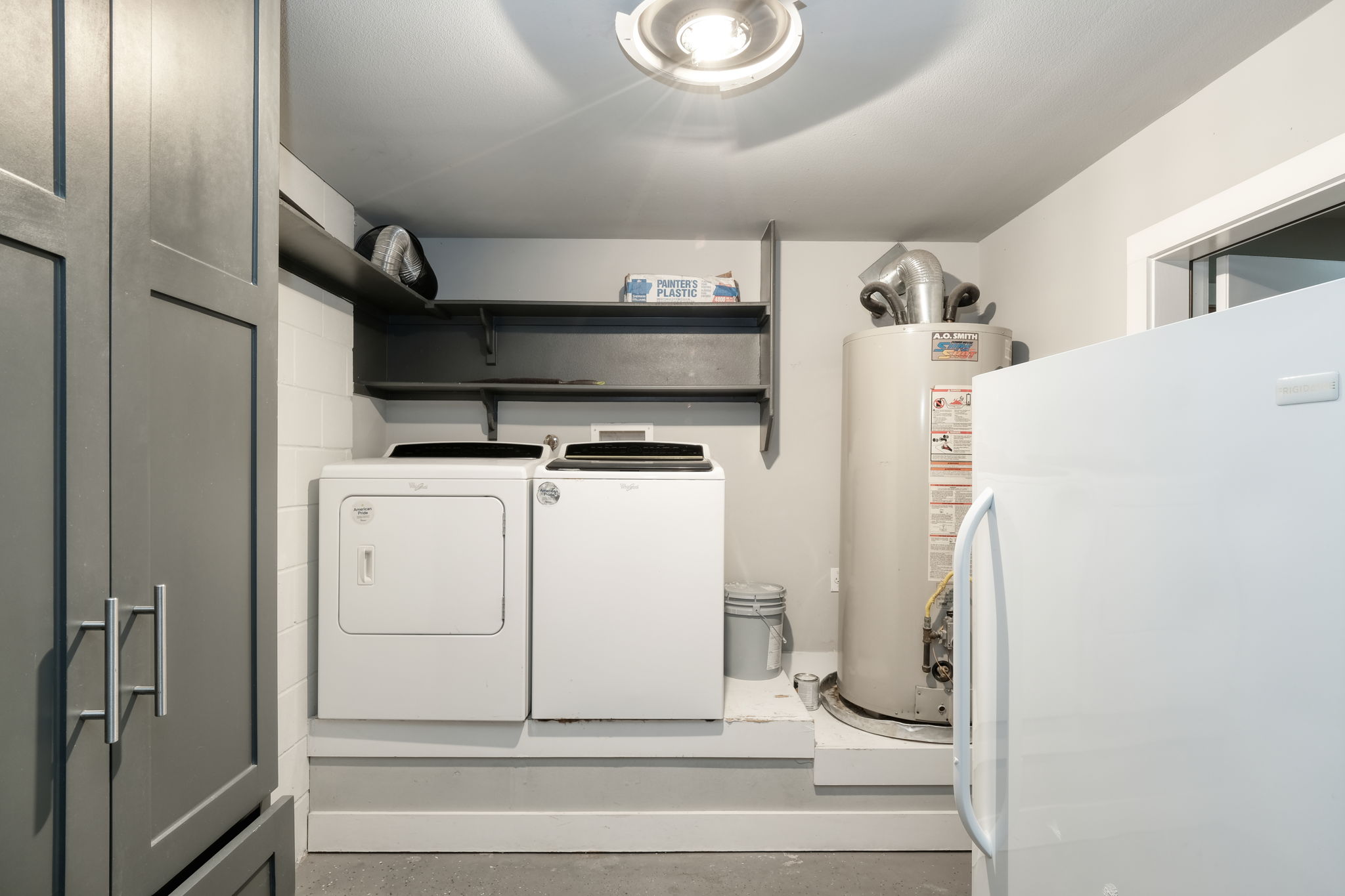 3000 Speedway Street, Unit E Austin, TX 78705 - Photo 11 of 16 Functional laundry room equipped with contemporary appliances, ample shelving, and a water heater.
