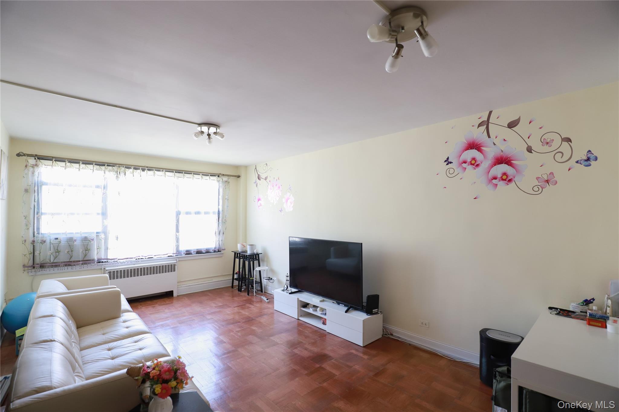 98-25 64th Road, Unit 6F Queens, NY 11374 - Photo 6 of 12 Spacious interior with parquet flooring and light-toned walls