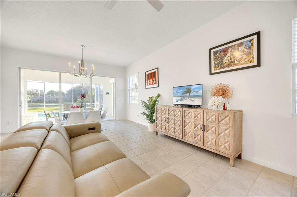 4708 Rio Poco Court Naples, FL 34109 - Photo 11 of 37 Living area with a chandelier, light tile patterned floors, and ceiling fan