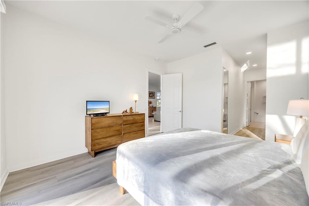 4708 Rio Poco Court Naples, FL 34109 - Photo 26 of 37 Bedroom featuring light wood-style floors, a ceiling fan, recessed lighting, and connected bathroom