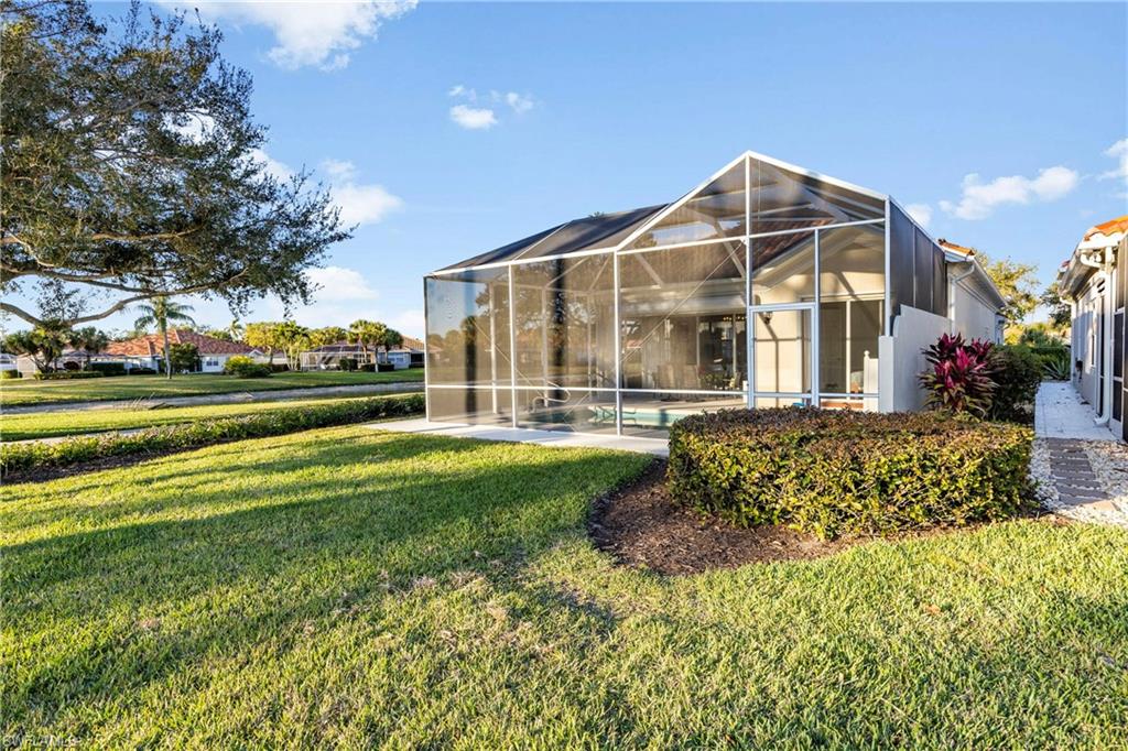 4708 Rio Poco Court Naples, FL 34109 - Photo 34 of 37 Back of property with a lanai, a sunroom, and a yard