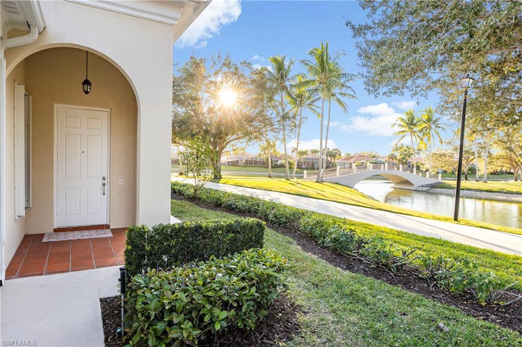 4708 Rio Poco Court Naples, FL 34109 - Photo 4 of 37 Doorway to property featuring a water view, a lawn, and stucco siding