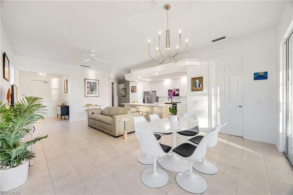 4708 Rio Poco Court Naples, FL 34109 - Photo 5 of 37 Dining room featuring a chandelier, ceiling fan, and light tile patterned flooring