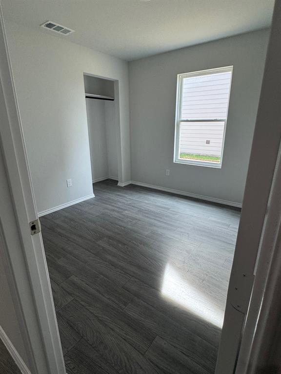 350 Azalea Trail Granbury, TX 76048 - Photo 14 of 18 an empty room with wooden floor and windows