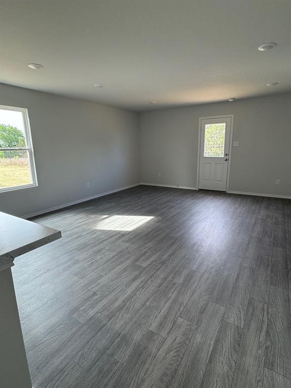 350 Azalea Trail Granbury, TX 76048 - Photo 10 of 18 an empty room with wooden floor and windows