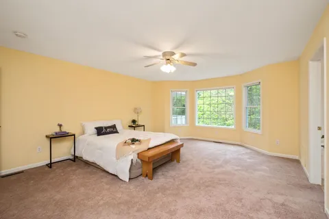 a spacious bedroom with a bed and a chandelier