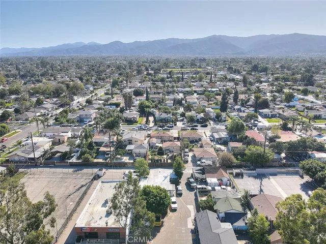 an aerial view of a town with covered mountains in the background