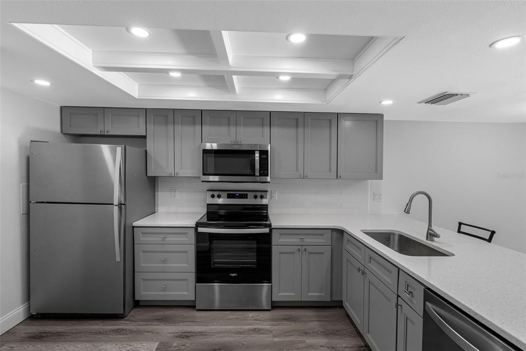 14001 Gulf Boulevard, Unit 404 Madeira Beach, FL 33708 - Photo 17 of 24 a kitchen with cabinets and stainless steel appliances
