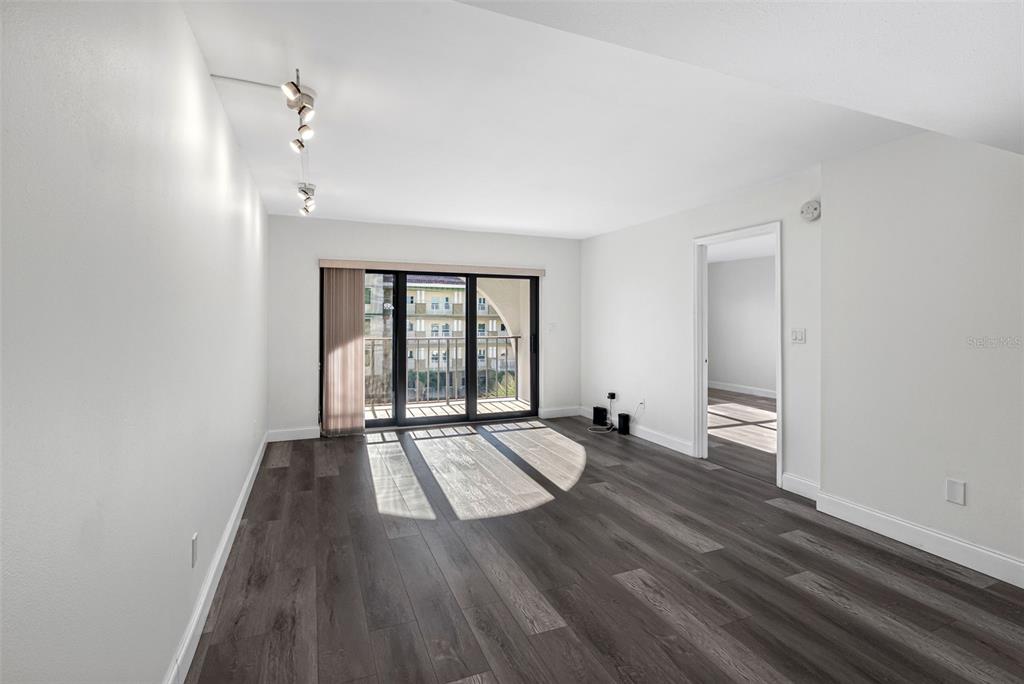 14001 Gulf Boulevard, Unit 404 Madeira Beach, FL 33708 - Photo 7 of 24 an empty room with wooden floor and windows