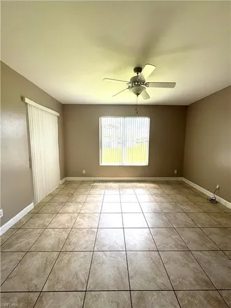 a view of an empty room and window chandelier fan