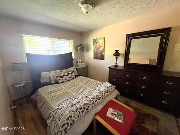 a bedroom with a bed and a flat tv screen on dresser