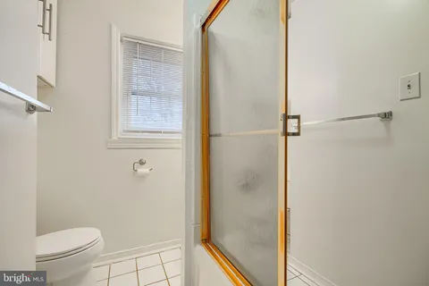 a bathroom with a granite countertop window a toilet and a shower