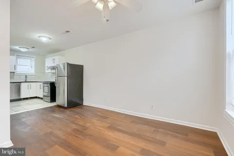 a view of kitchen with refrigerator cabinets and wooden floor