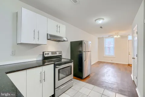 a kitchen with white cabinets and stainless steel appliances
