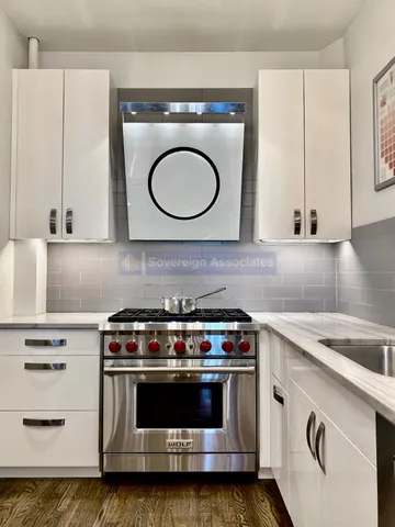 a large kitchen with stainless steel appliances a large counter top