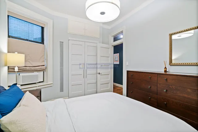 a bedroom with a bed and a flat tv screen on the dresser