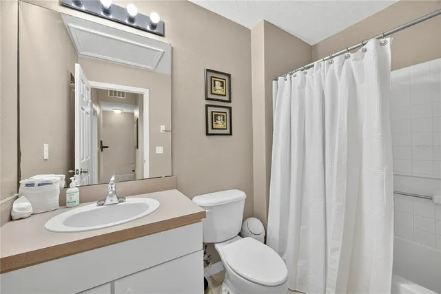 a bathroom with a granite countertop sink toilet a mirror and shower