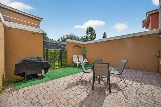 a view of a chair and table in backyard of the house