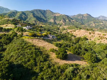 a view of a mountain range with lush green forest