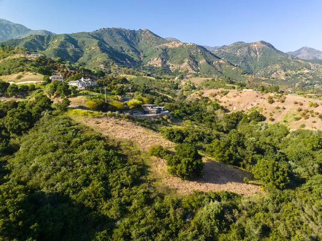 a view of a mountain range with lush green forest