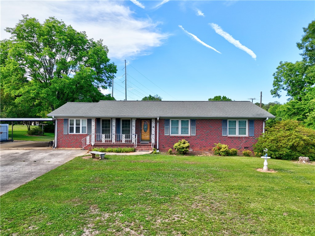 307 Calhoun Road Belton, SC 29627 - Photo 2 of 30 A charming brick ranch home with a welcoming front porch and well-maintained green lawn.