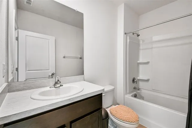 a bathroom with a sink toilet vanity and shower