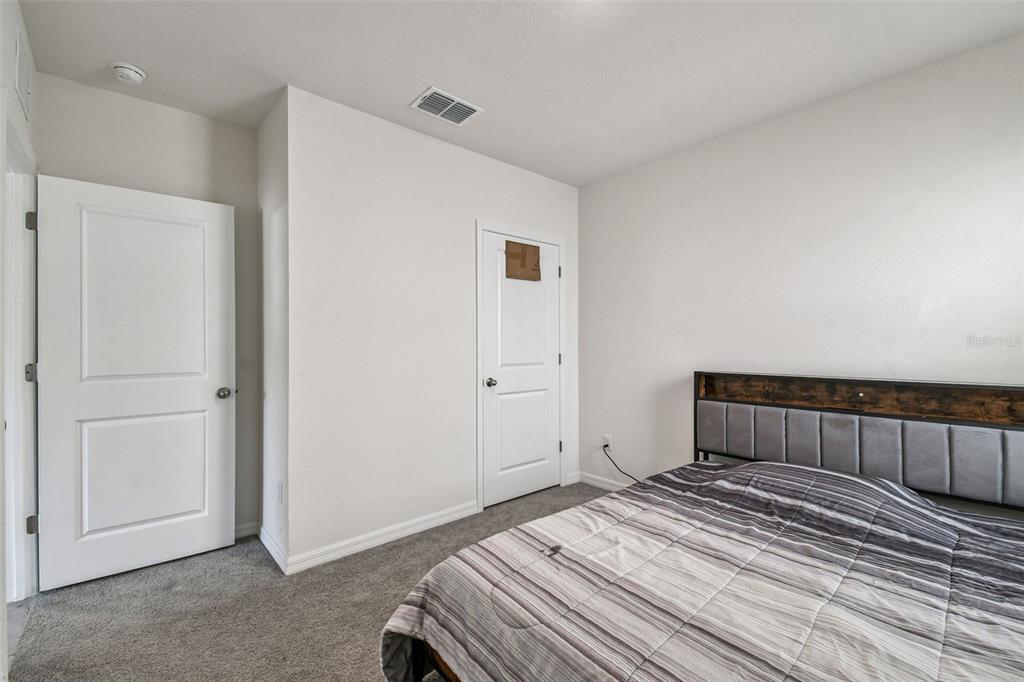 33635 Field Maple Loop Wesley Chapel, FL 33545 - Photo 14 of 35 a bedroom with a bed and wooden floor