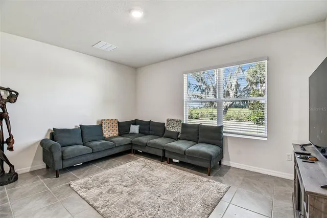 a view of kitchen with microwave a refrigerator and chairs