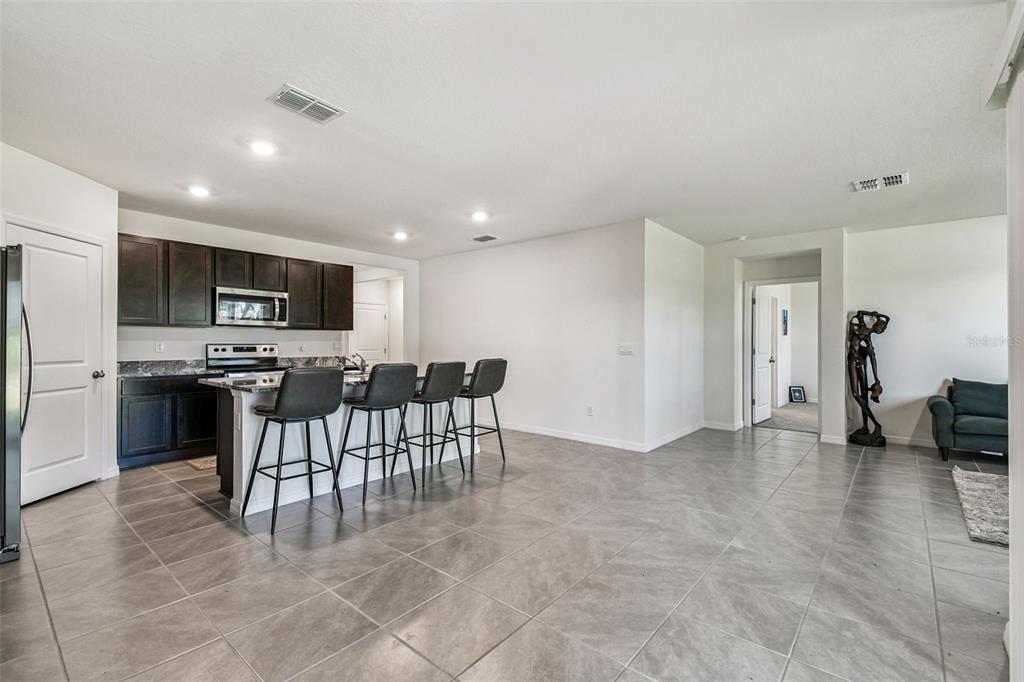 33635 Field Maple Loop Wesley Chapel, FL 33545 - Photo 19 of 35 a view of kitchen with microwave a refrigerator and chairs