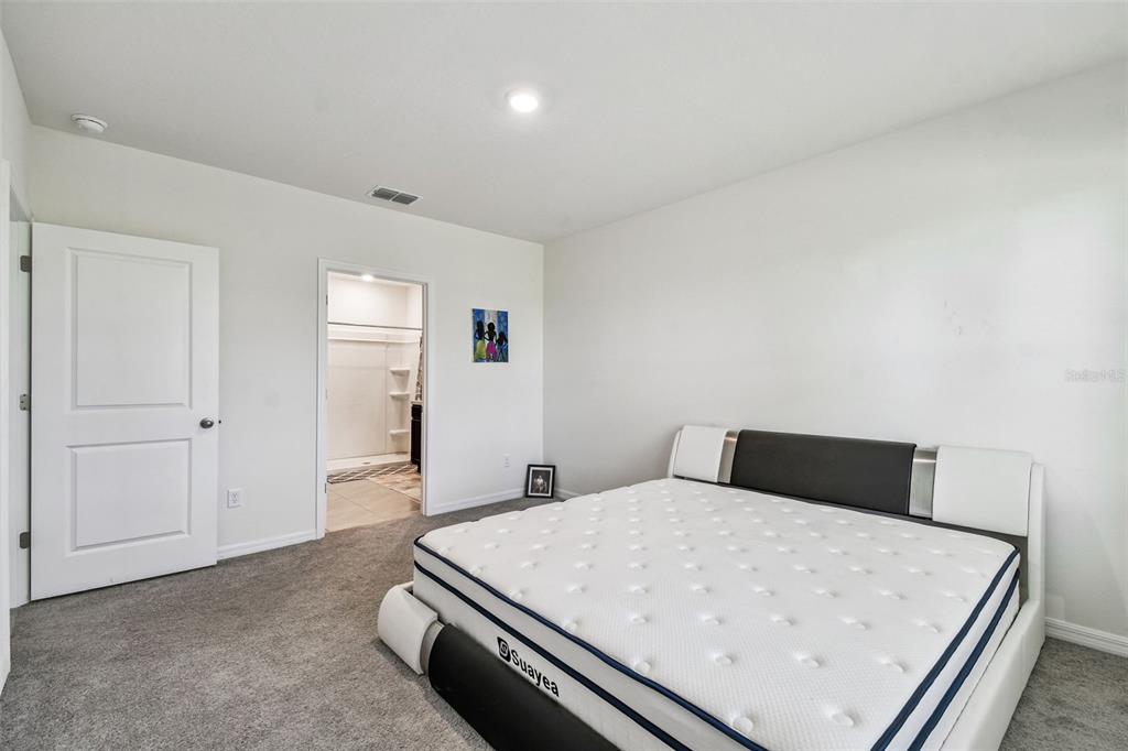 33635 Field Maple Loop Wesley Chapel, FL 33545 - Photo 22 of 35 a bedroom with a bed and a refrigerator