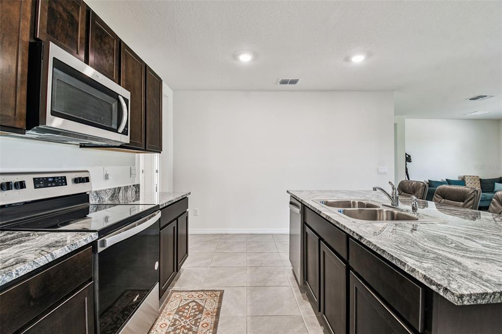 33635 Field Maple Loop Wesley Chapel, FL 33545 - Photo 7 of 35 a kitchen with a sink stove and microwave
