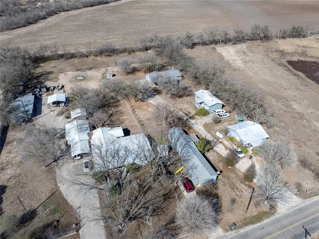 a view of a dry yard with trees