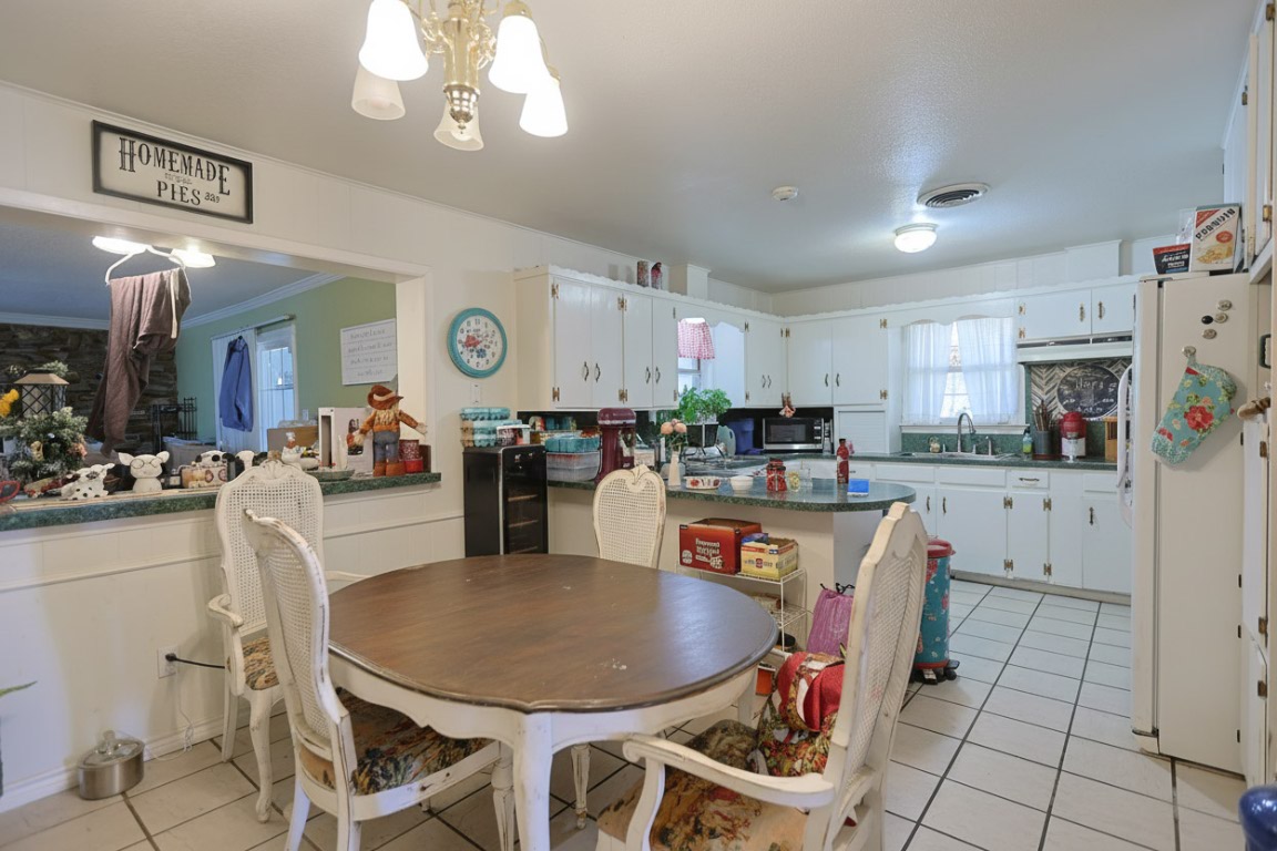 1403 Harris Hill Road San Marcos, TX 78666 - Photo 9 of 13 a kitchen with stainless steel appliances kitchen island granite countertop a dining table chairs and a refrigerator