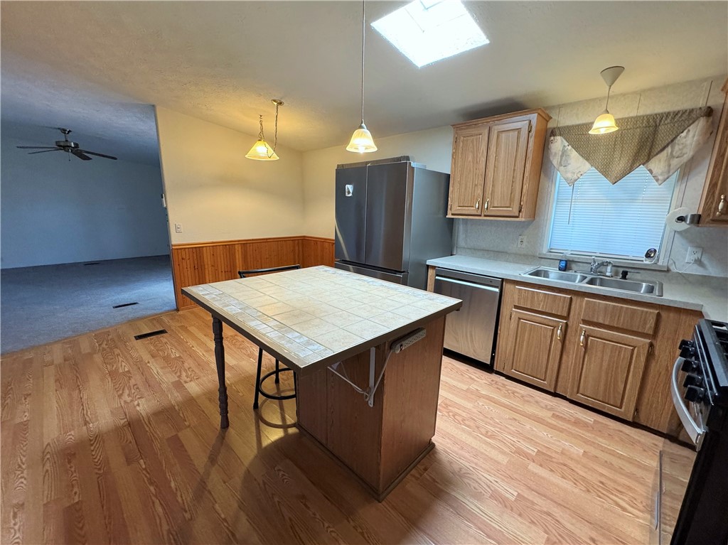 14224 East Randy Ranch Road Kingman, AZ 86401 - Photo 12 of 75 The kitchen features wood plank flooring, a skylight, a tile-topped island, and stainless steel appliances