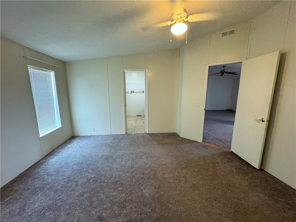 14224 East Randy Ranch Road Kingman, AZ 86401 - Photo 20 of 75 This room features carpeted flooring, a window with blinds, and a ceiling fan
