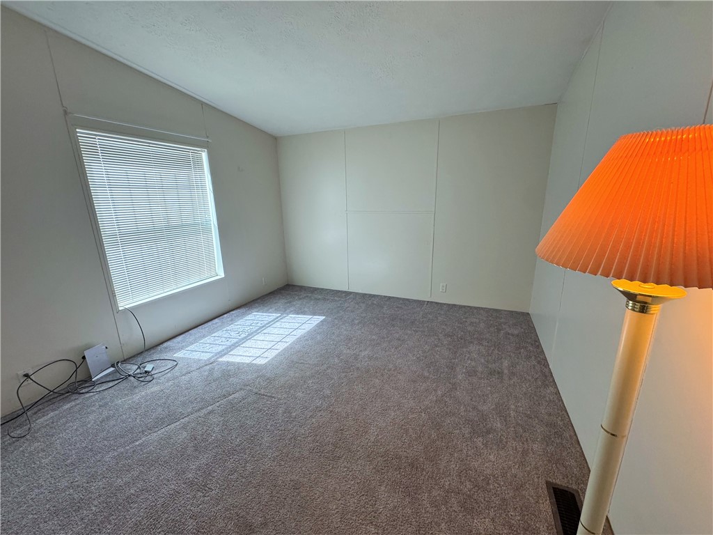 14224 East Randy Ranch Road Kingman, AZ 86401 - Photo 22 of 75 The room features a window with blinds, light-colored walls, and a grey carpet