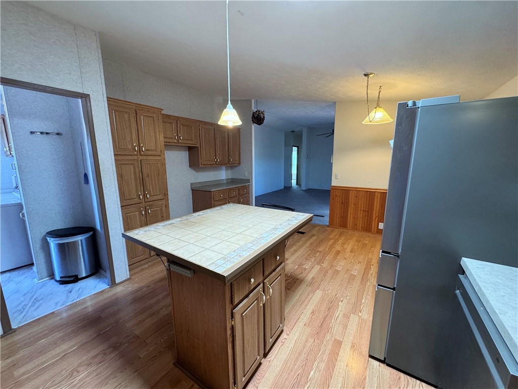 14224 East Randy Ranch Road Kingman, AZ 86401 - Photo 24 of 75 The kitchen features wood cabinetry, a tiled kitchen island, and hard surface flooring