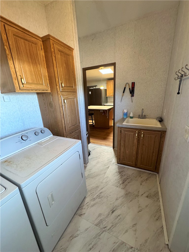 14224 East Randy Ranch Road Kingman, AZ 86401 - Photo 27 of 75 The property features a laundry area with overhead cabinetry, a utility sink with under-sink storage, and durable flooring
