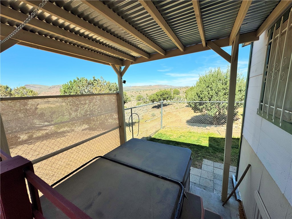 14224 East Randy Ranch Road Kingman, AZ 86401 - Photo 31 of 75 The property features a covered patio with a corrugated metal roof, offering views of the expansive landscape