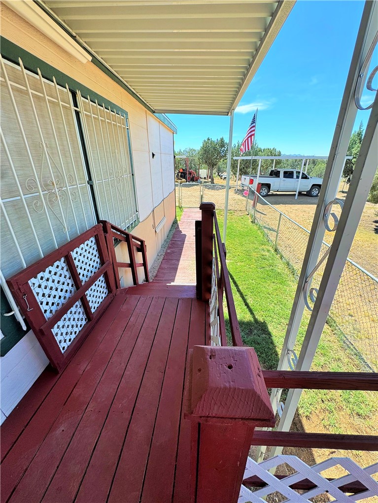 14224 East Randy Ranch Road Kingman, AZ 86401 - Photo 33 of 75 The property features a covered porch with a red wooden deck and railings
