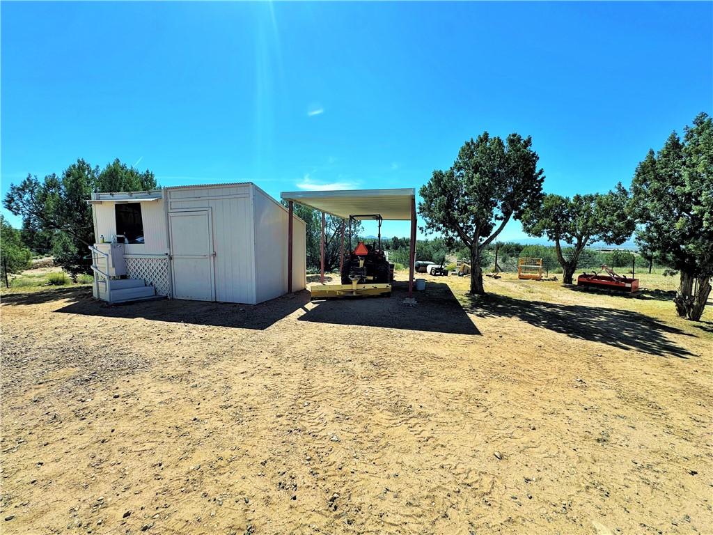 14224 East Randy Ranch Road Kingman, AZ 86401 - Photo 35 of 75 The property includes a white utility building with a covered porch and steps