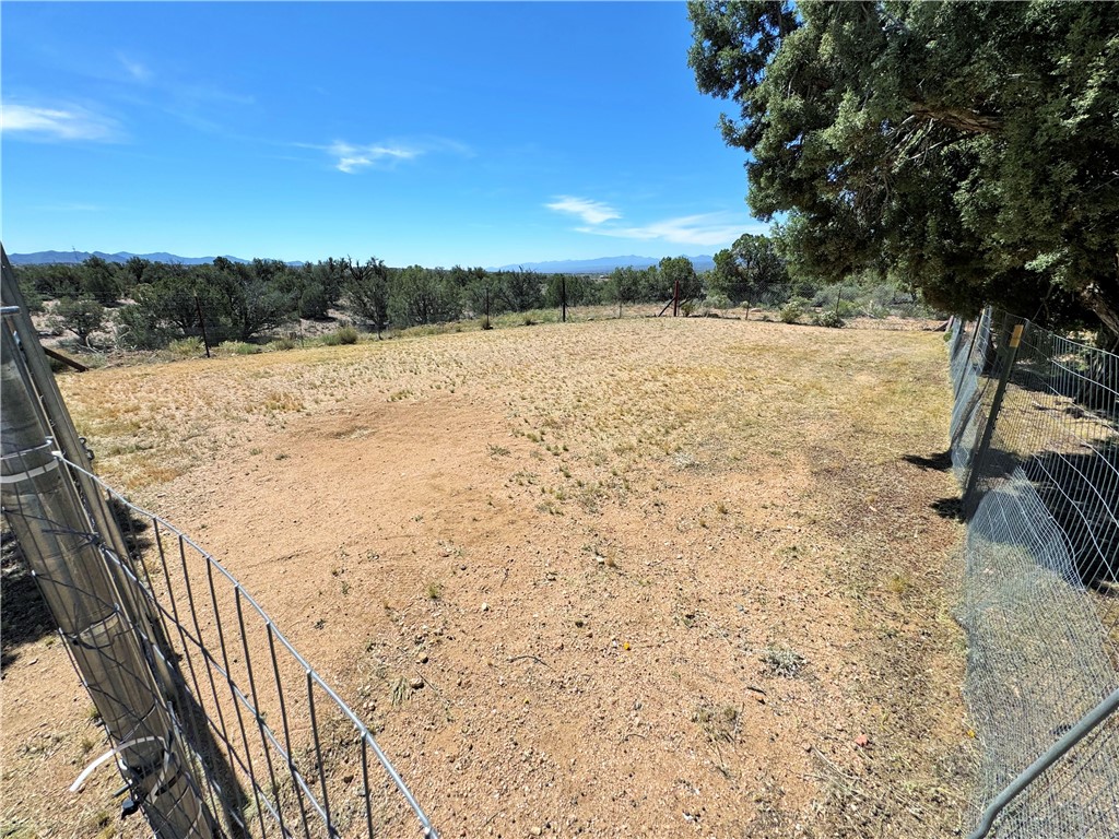 14224 East Randy Ranch Road Kingman, AZ 86401 - Photo 38 of 75 The property features a spacious, open lot with a wire fence and a mature tree