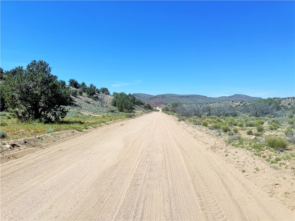 14224 East Randy Ranch Road Kingman, AZ 86401 - Photo 56 of 75 The property features a dirt road leading towards distant hills and a clear blue sky